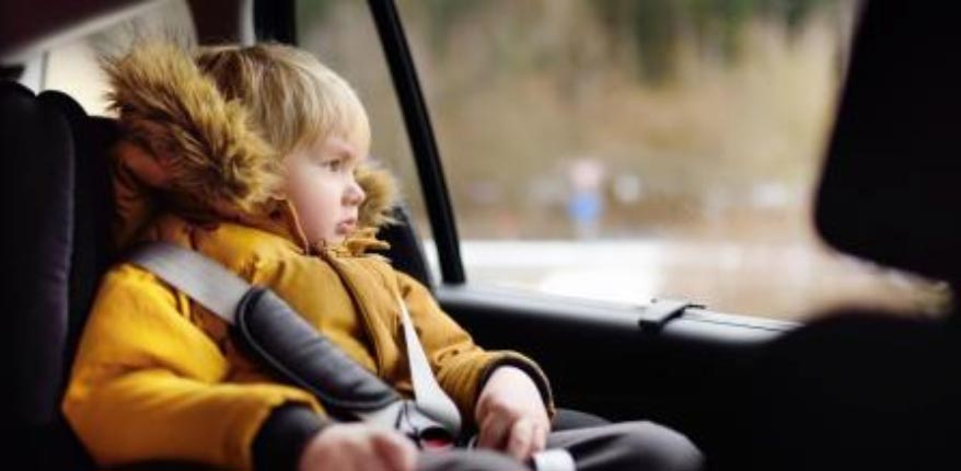 niño con abrigo en coche